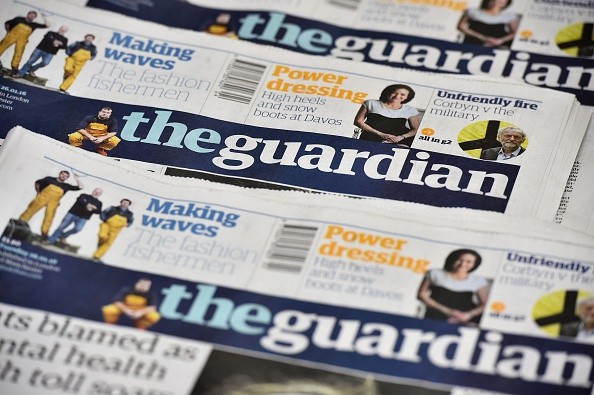 An arrangment of Guardian newspapers is photographed in an office in London on January 26, 2016. The Guardian newspaper is to cut running costs by 20 percent over three years and may begin charging for some online content following a 25-percent plunge in print advertising, British media reported Tuesday. / …