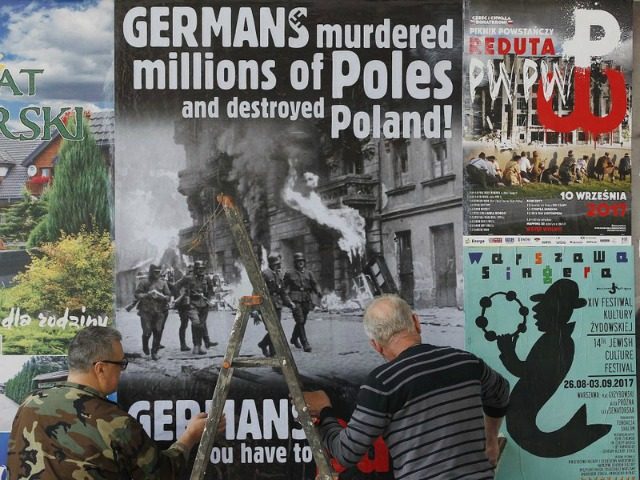 In this Aug. 24, 2017 photo a workers puts up a poster in Warsaw, Poland, calling on Germany to pay reparations for World War II to Poland. Poland’s government is calling on Germany to pay it reparations for World War II, when more than five years of brutal Nazi occupation …