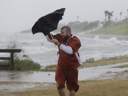 Matt Looingvill struggles with his umbrella as he tries to walk in the wind and rain, Frid