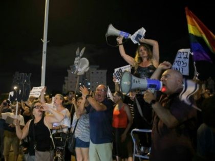 Israelis take part in a weekly protest against Israeli Prime Minister Benjamin Netanyahu, seen on the poster, in front of the home of Israel's attorney general Avichai Mandelblit in Petah Tikva. Saturday, Aug. 26, 2017. The weekly vigils have become the vanguard of a grassroots protest movement against Netanyahu's alleged …