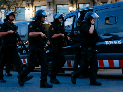 Spanish policemen walk in a cordoned off area after a van ploughed into the crowd, killing 13 persons and injuring over 80 on the Rambla in Barcelona on August 17, 2017.