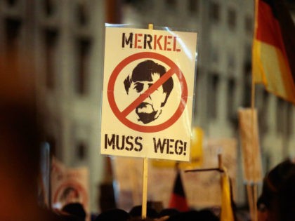 MUNICH, GERMANY - JANUARY 11: Supporters of the right-wing populist group Pegida, holding a placard 'Merkel muss weg' ('Merkel Off') march on January 11, 2016 in Munich, Germany. Pegida and other right-wing activists have been quick to latch on to the New Year's Eve sex attacks in Cologne. Over 100 …
