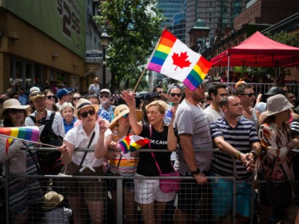 TORONTO, CANADA - JULY 3: Spectators watch along Yonge Street, at the annual Pride Festiva