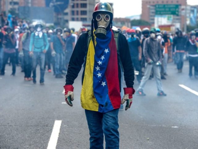 TOPSHOT - Opposition activists protest against President Nicolas Maduro, in Caracas on May 8, 2017. Venezuela's opposition mobilized Monday in fresh street protests against President Nicolas Maduro's efforts to reform the constitution in a deadly political crisis. Supporters of the opposition Democratic Unity Roundtable (MUD) gathered in eastern Caracas to …