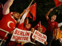 GettyImages-815253554 BERLIN, GERMANY - JULY 15: Pro-Erdogan Berlin Turks, including some holding signs in Turkish that read: 'Berlin Holds Watch,' wave Turkish flags during a gathering in front of the Turkish Embassy to commemorate the first anniversary of the failed coup in Turkey on July 15, 2017 in Berlin, Germany. Hundreds …
