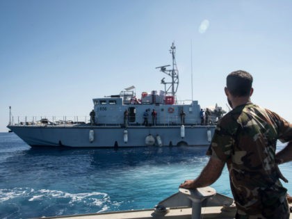 A Libyan coastguard looks towards a ship as he patrols the area at sea between Sabratha and Zawiyah on July 28, 2017. / AFP PHOTO / TAHA JAWASHI (Photo credit should read TAHA JAWASHI/AFP/Getty Images)