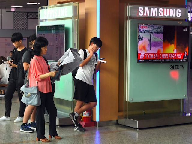 People stand next to a television screen showing a video footage of North Korea's tests launch of intercontinental ballistic missiles (ICBM), at a railway station in Seoul on July 29, 2017. North Korean leader Kim Jong-Un said on July 29 the country's second ICBM test demonstrated the ability to strike …