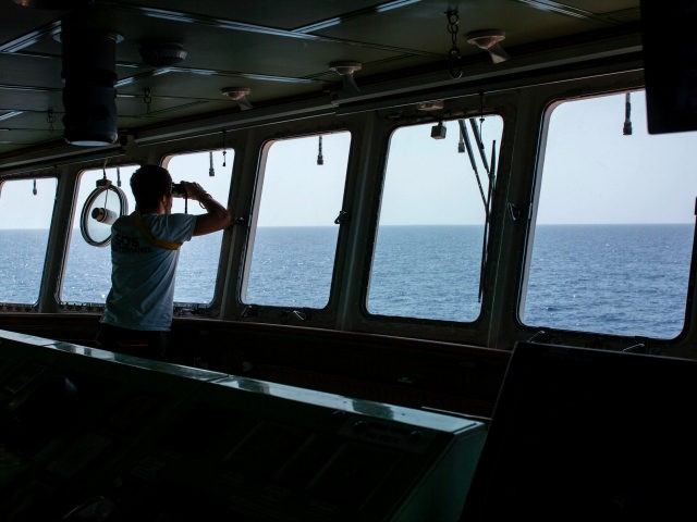 A member of the Aquarius rescue ship of the European search and rescue association 'SOS Mediterranee', uses binoculars during a search operation on the Mediterranean Sea, 20 nautical miles from the Libyan coast, on August 11, 2017. The Libyan navy on August 11, 2017, ordered foreign vessels to stay out …