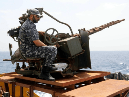 A member of the Libyan coastguard mans a machinegun on a patrol boat off the coast of Misr