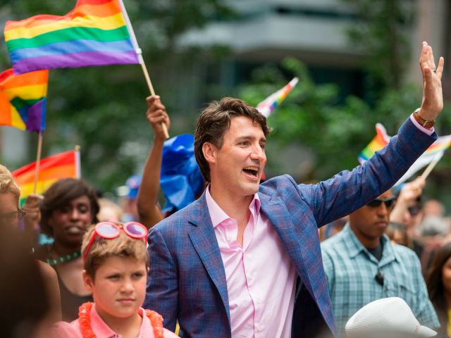 Prime Minister Justin Trudeau waves to the crowd as he marches in the Pride Parade in Toro