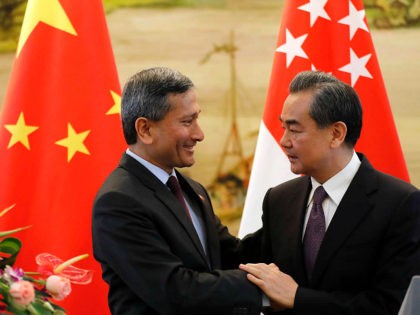 Singapore's Foreign Minister Vivian Balakrishnan, left, shakes hands with Chinese Foreign Minister Wang Yi after a joint press conference following their meeting at the Ministry of Foreign Affairs in Beijing Monday, June 12, 2017. (AP Photo/Andy Wong)