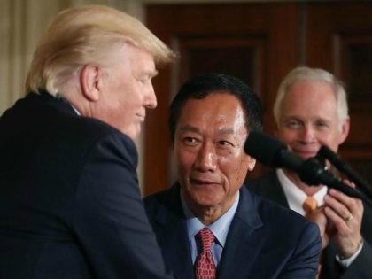 US President Donald Trump shakes hands with Terry Gou (C), Chairman of Foxconn, an electronics supplier, while Sen. Ben Johnson (R-WI) (R) stands nearby during an announcement that the company will open a manufacturing facility in Wisconsin, during an event in the East Room of the White House July 26, …