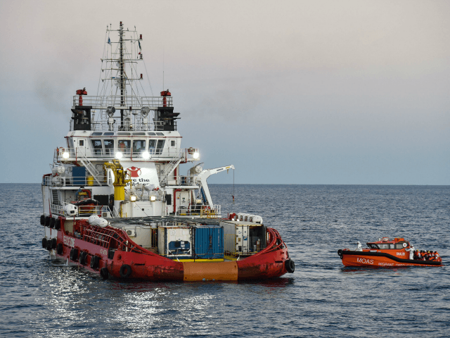 Migrants and refugees are transferred from the Topaz Responder ship run by Maltese NGO 'Moas' and the Italian Red Cross to the Vos Hestia ship run by NGO 'Save the Children', on November 4, 2016, a day after a rescue operation off the Libyan coast in the Mediterranean Sea.