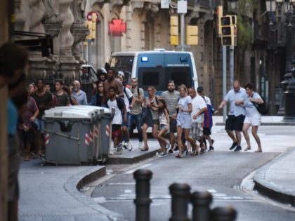 People flee from the scene after a white van jumped the sidewalk in the historic Las Rambl