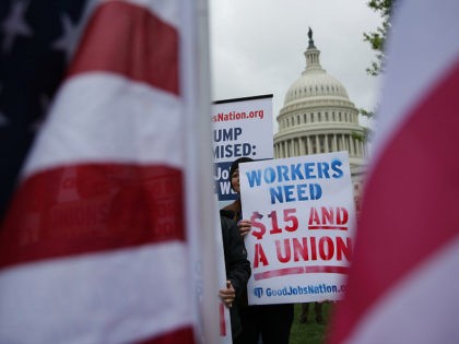 WASHINGTON, DC - APRIL 26: An activist holds a sign during a rally in front of the Capitol April 26, 2017 in Washington, DC. Activists and low-wage workers gathered on Capitol Hill to rally for a $15 minimum and rights to form unions. (Photo by Alex Wong/Getty Images)