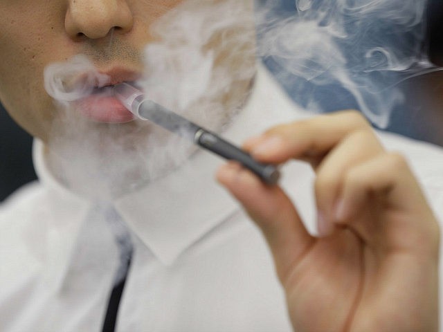 An attendant demonstrates Japan Tobacco Inc.'s Ploom Tech smokeless tobacco device for a p