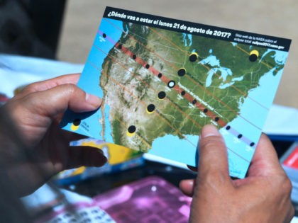 A woman views a map showing the route of the sun crossing the United States during the Sol