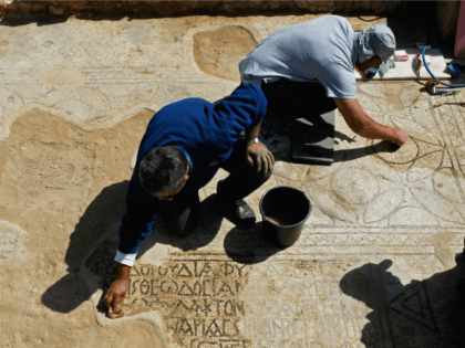 NES HARIM, ISRAEL - MARCH 12: Israeli archaeologists clean a mosaic in the ruins of a church that dates back to the Byzantine period (6th-7th century AD) which was recently unearthed during construction work, on March 12, 2009 in the community of Nes Harim near Jerusalem, Israel. The mosaic is …