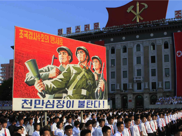 North Koreans wave banners and shout slogans at a state organised anti-American rally in P