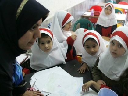 Iranian girls gather around their teacher in the clasroom at Sizdah Abban school in north
