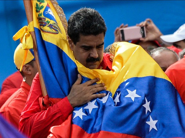 Venezuelan President Nicolas Maduro holds a national flag during the closing of the campai