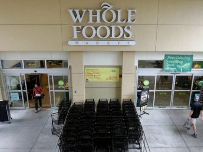 Customers shop at a Whole Foods Market, Monday, Aug. 28, 2017, in Tampa, Fla. Parent company Amazon has announced they will drop the prices on certain food items at the stores. (AP Photo/Chris O'Meara)