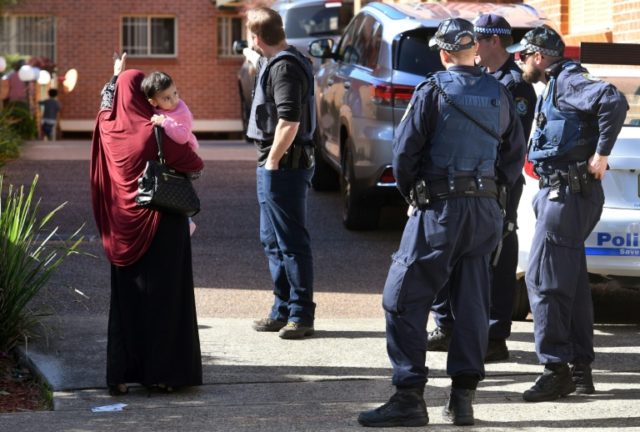 Police direct locals around a block of flats in the Sydney suburb of Lakemba after counter