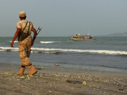 A pro-government forces soldier walks along the beach in the southern coastal city of Aden