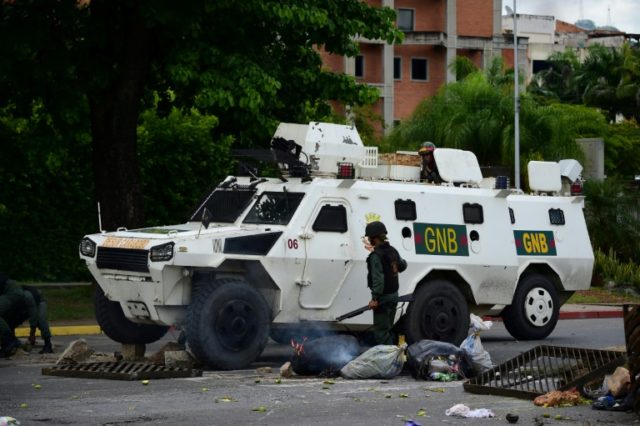 Members of the Venezuelan National Guard clear a barricade set by anti-government activist