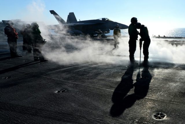 An F/A-18E Super Hornet prepares for takeoff from the flight deck of the USS Nimitz in 201