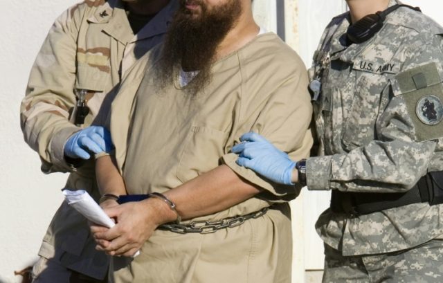 A detainee is escorted by military guards at the US prison at Guantanamo Bay, Cuba, in a 2