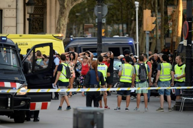 Policemen check the identity of people in Barcelona after a van ploughed into a crowd of p