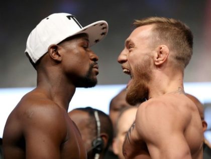 Boxer Floyd Mayweather Jr. (L) and UFC lightweight champion Conor McGregor face off during their official weigh-in at T-Mobile Arena on August 25, 2017 in Las Vegas, Nevada
