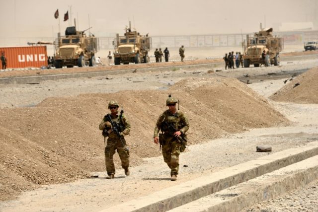 US soldiers walk at the site of a Taliban suicide attack in Kandahar on August 2, 2017