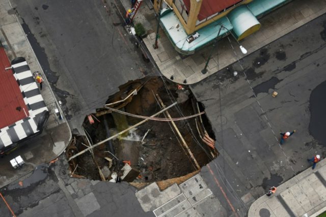 Civil protection crews in Mexico City work to repair a huge hole that opened up after heav