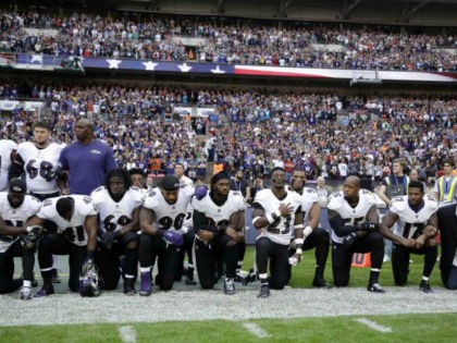 Baltimore Ravens players, including former player Ray Lewis, second from right, kneel down during the playing of the U.S. national anthem before an NFL football game against the Jacksonville Jaguars at Wembley Stadium in London, Sunday Sept. 24, 2017. (AP Photo/Matt Dunham)