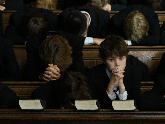 Pupils of Eton College bow their heads in prayer during the daily service in College Chapel at the iconic English private school, Eton College. Eton College was founded in 1440 by King Henry VI. The College originally had 70 King's Scholars or 'Collegers' who lived in the College and were …