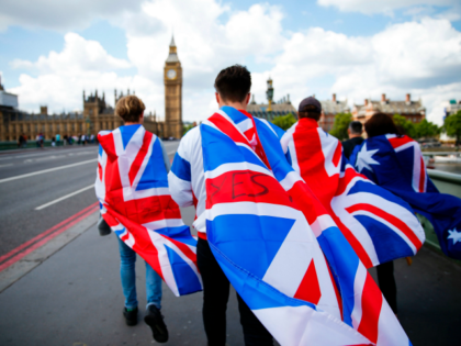 People walk over Westminster Bridge wrapped in Union flags, towards the Queen Elizabeth To