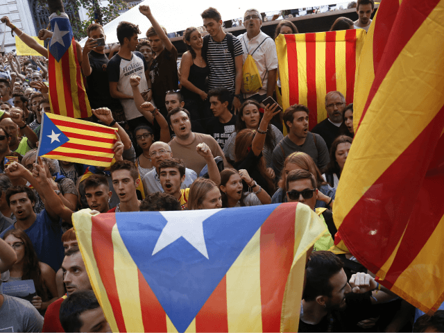 People hold 'Esteladas' (Catalan pro-independence flags) during a protest in fro