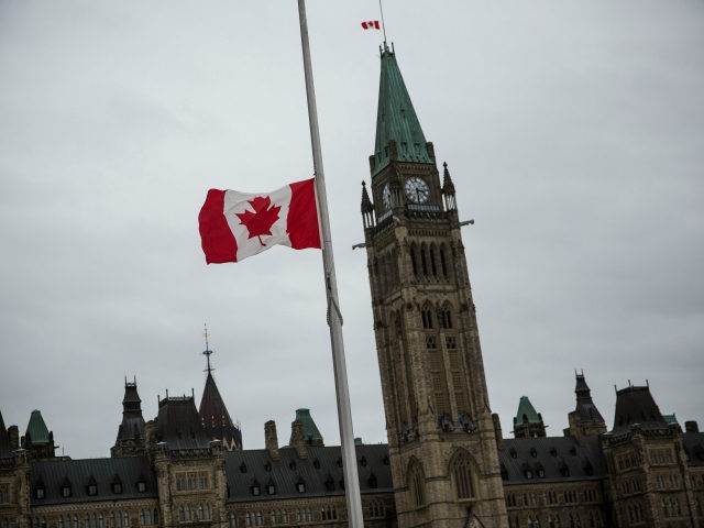 OTTAWA, ON - OCTOBER 23: A flag next to the Canadian Parliament Building is flown at half staff one day after Cpl. Nathan Cirillo of the Canadian Army Reserves was killed while standing guard in front of the National War Memorial by a lone gunman, on October 23, 2014 in …