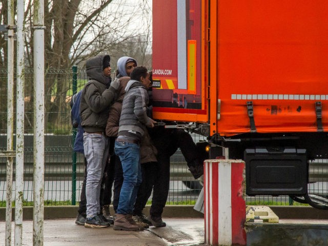 TOPSHOT - Migrant men get into the back of a semi-trailer at a service station off the A25