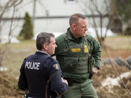 An Royal Canadian Mounted Police officer speaks with a US Boarder Patrol agent at an uncontrolled border crossing near Hemmingford Quebec, February 25 2017. The Royal Canadian Mounted Police said there has been a significant increase over the past few months in the number of people illegally crossing the border, …