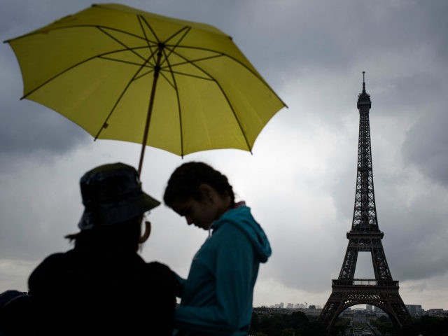 Tourists walk with umbrellas at Trocadero near the Eiffel Tower as it rains in Paris on August 10, 2017. / AFP PHOTO / PHILIPPE LOPEZ (Photo credit should read PHILIPPE LOPEZ/AFP/Getty Images)