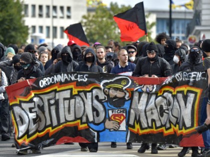 People march behind a banner reading 'Let's depose Macron' (refering to Fre