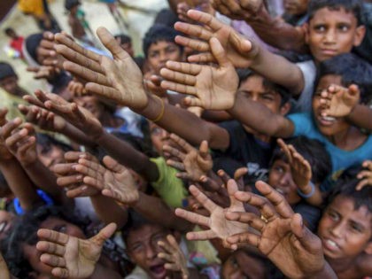 Rohingya Muslim children, who crossed over from Myanmar into Bangladesh, stretch their arms out to collect chocolates and milk distributed by Bangladeshi men at Taiy Khali refugee camp, Bangladesh, Thursday, Sept. 21, 2017. More than 400,000 Rohingya Muslims have fled to Bangladesh since Aug. 25, when deadly attacks by a …