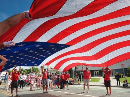 Participants carry an American flag during the 4th of July parade in Santa Monica, Calif.