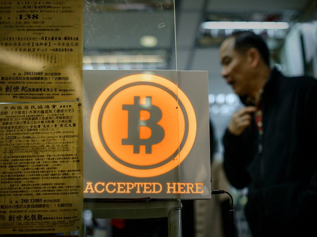A man walks out of a shop displaying a bitcoin sign during the opening ceremony of the fir