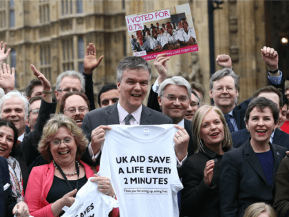 MPs and campaigners from Non Governmental Organisations take part in a photocall following the passing of a law of a committing Britain to spend 0.7% of its gross national income on foreign aid on March 9, 2015 in London, England.