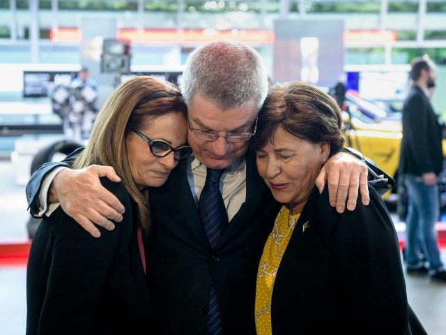 President of the International Olympic Committee Thomas Bach comforts Ilana Romano, widow
