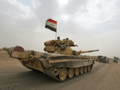 Iraqi soldiers pictured on a Russian-made T-72 tank as they advance towards the city of al-Sharqat, north of Baghdad, on September 20, 2017